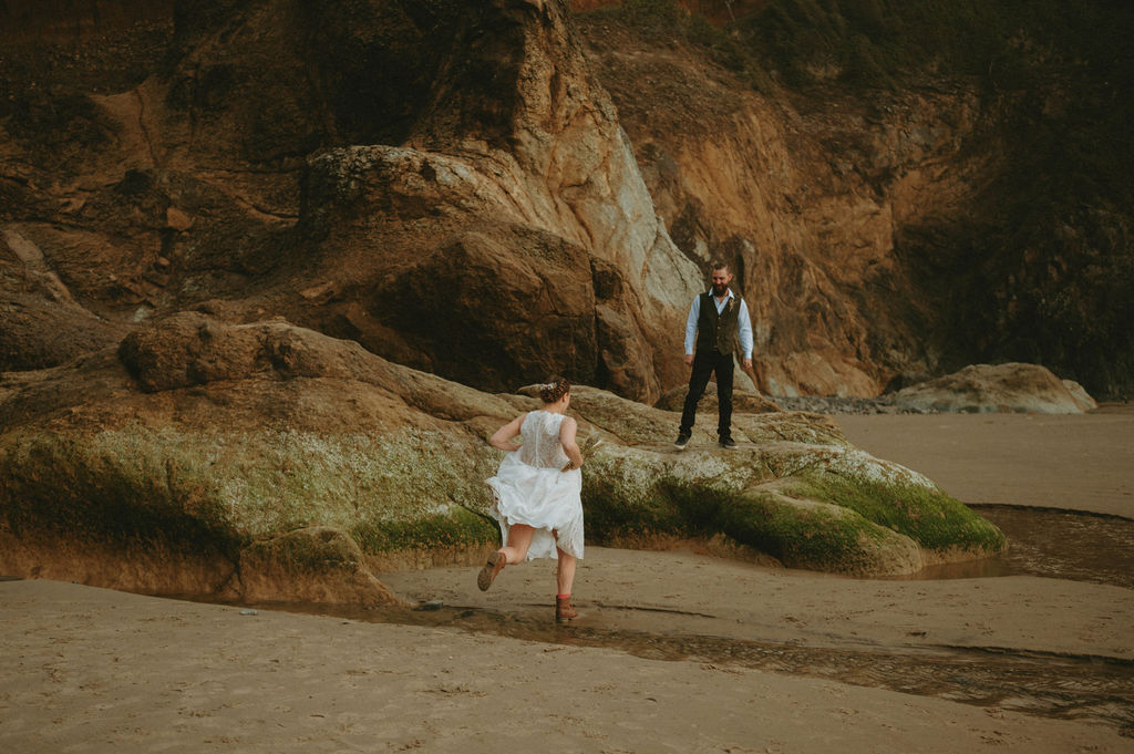 newly eloped couple at hug point oregon beach for elopement with waterfall backdrop